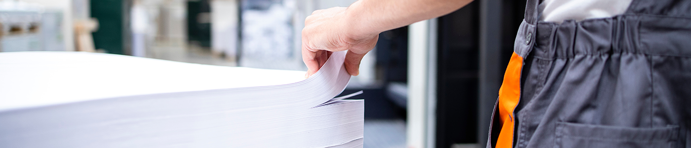 person flipping through a large stack of coated accent paper