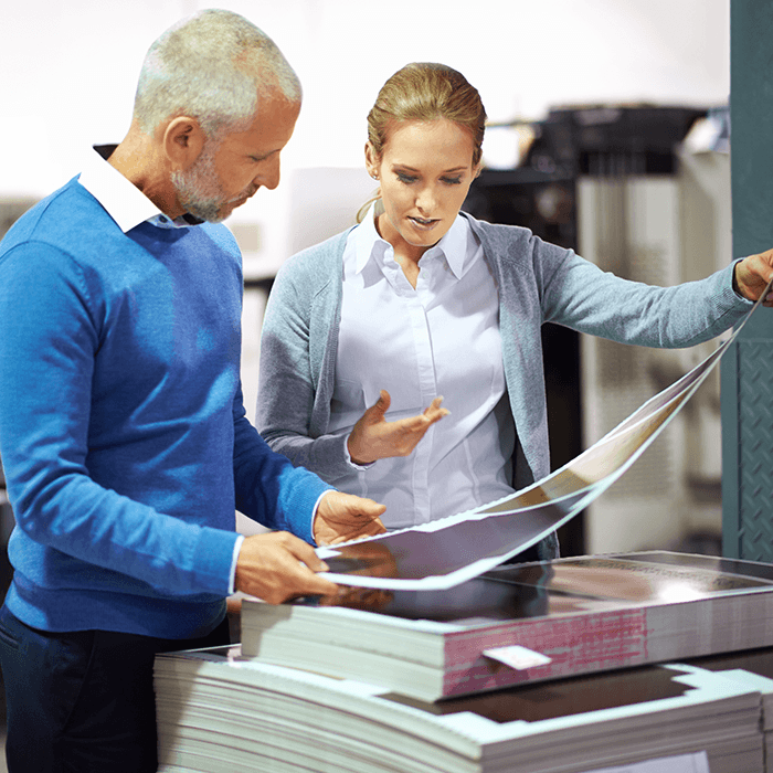 Man and woman looking at paper that was recently printing on.